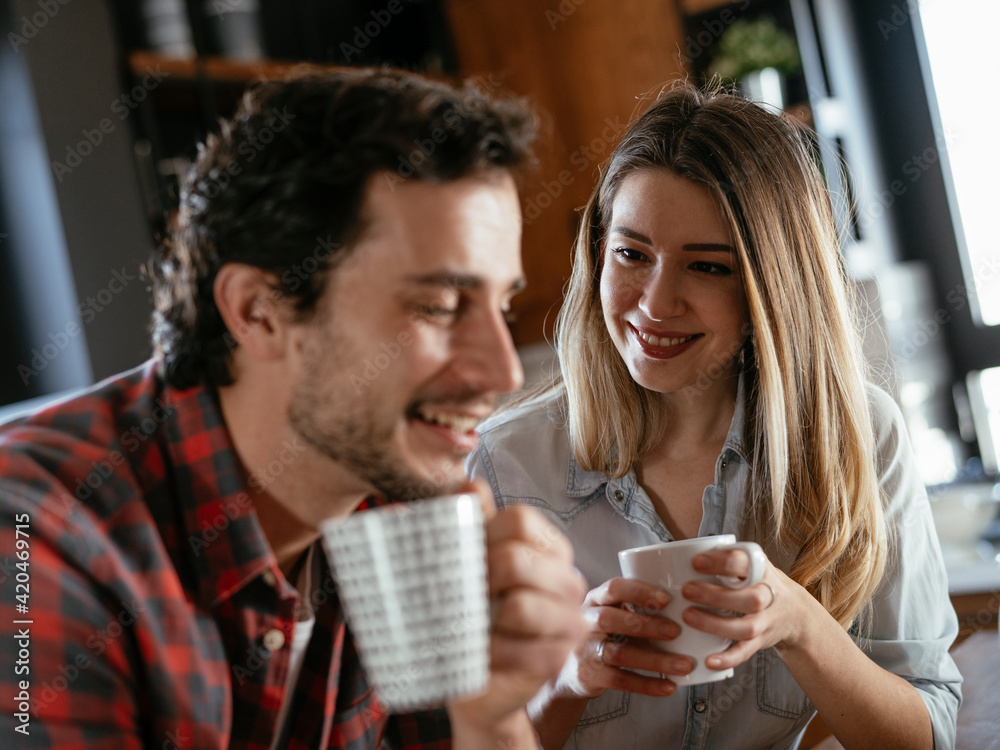 Loving couple drinking coffe in the kitchen. Happy smiling wife enjoy in the morning with her husband. Loving couple drinking coffe in the kitchen. Happy smiling wife enjoy in the morning with her husband.
