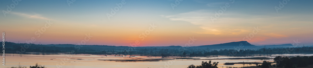 Beautiful sky painted by the sun leaving bright golden shades.Dense clouds in twilight sky in winter evening.Image of cloud sky on evening time.Evening sky scene with golden light from the setting sun