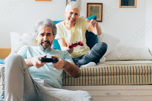 Senior couple playing video games at home