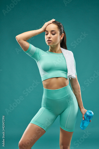 Beautiful young woman in sportswear holding bottle of water