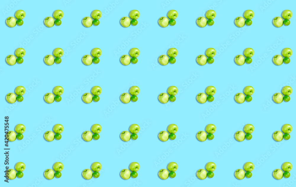 A pattern with green lime and apples on a blue background. Fruit diet background. A pattern with green lime and apples on a blue background. Fruit diet background.