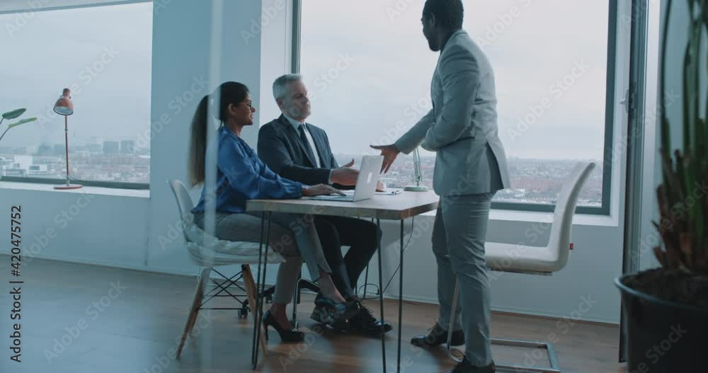 Couple of multi-ethnic businessmen and woman doing handshake on business meeting Couple of multi-ethnic businessmen and woman doing handshake on business meeting