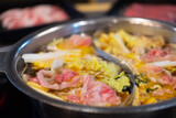 Sliced meat and vegetables boiled in double flavor hot pot.