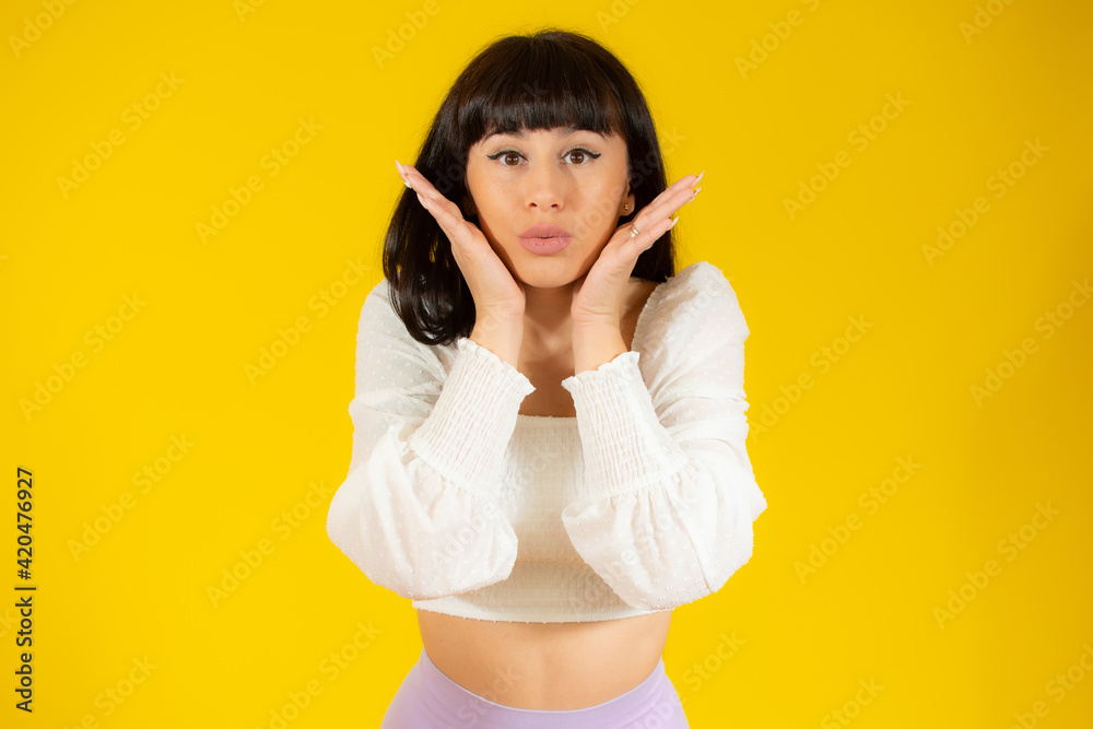 Portrait of a pensive casual woman isolated over yellow background Portrait of a pensive casual woman isolated over yellow background