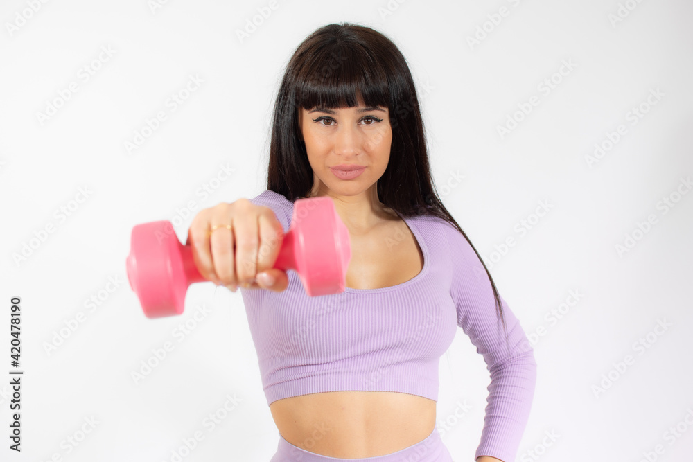 Photo of a healthy training young woman with dumbbell. Healthy lifestyle concept. Photo of a healthy training young woman with dumbbell. Healthy lifestyle concept.