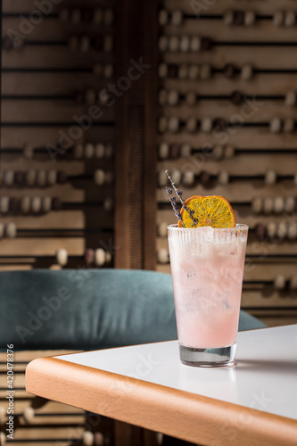 Natural lemonade with lavender and orange in tall glass on the table at restaurant