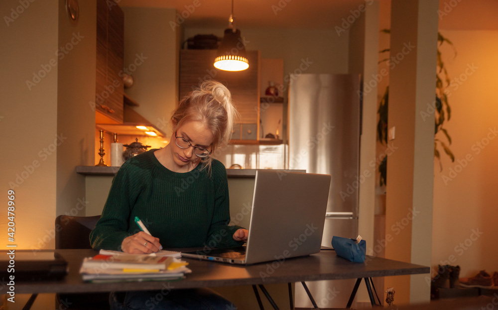 one young woman, working at her home, on her laptop. one young woman, working at her home, on her laptop.