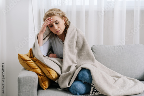Photographie Ill woman covered with blanket sit on sofa