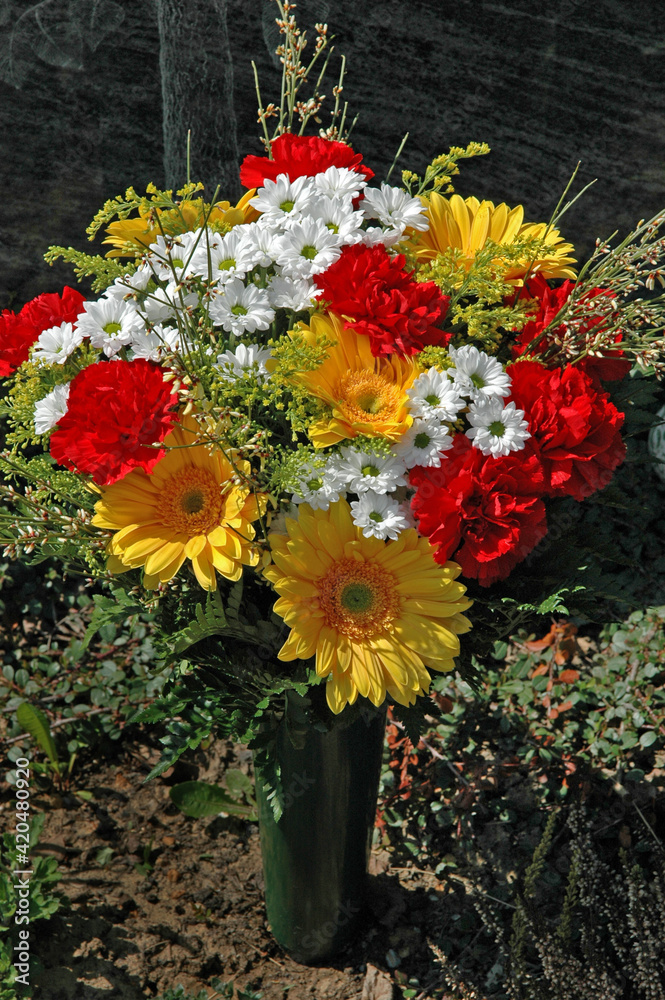Fototapeta premium Bunte Fruehlingsblumen auf einem Grab