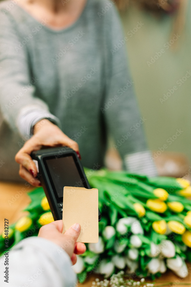 Using the dataphone to pay with golden card at the flower shop Using the dataphone to pay with golden card at the flower shop