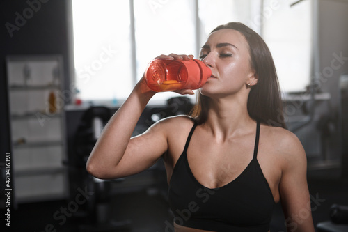 Beautiful sportswoman drinking water after working out © mad_production