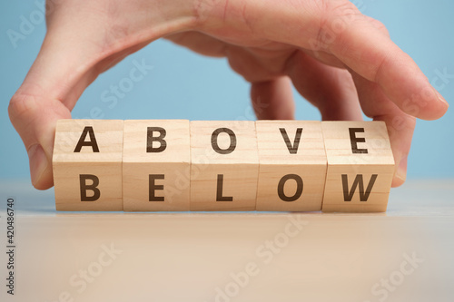 Concept of antonym above and below on wooden blocks