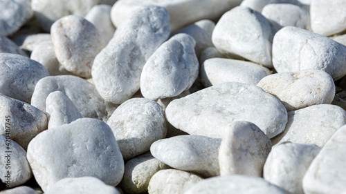 Close-up of light gray pebbles, smooth stones in a wrap-up plan as a background or wallpaper