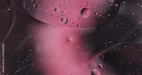 Oil bubbles on water abstract form in glass tank.