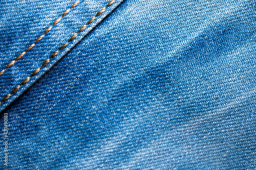Background on the theme of denim clothing. Denim fabric with elements of seams.