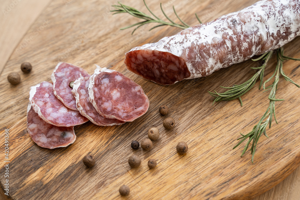 Traditional salami sliced on cutting board. Top view on dark slate table Traditional salami sliced on cutting board. Top view on dark slate table