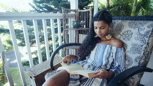 Woman reading book on deck photo