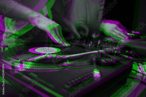 Fotografija Abstract background with hip hop dj scratching vinyl records on turntable in night club edited with 3D anaglyph effect
