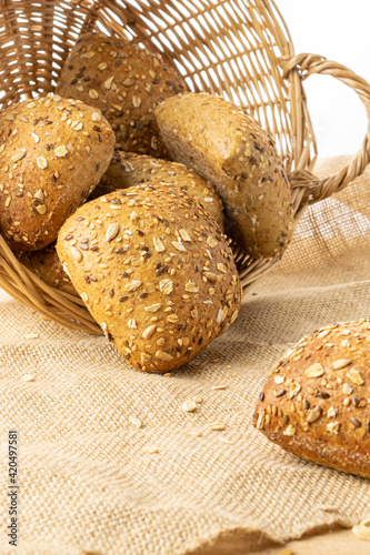Rye bread isolated. Bakery with crusty loaves and crumbs. Fresh loaf of rustic traditional bread with wheat grain ear or spike plant on natural cotton background. Bio ingredients, healthy with seeds.