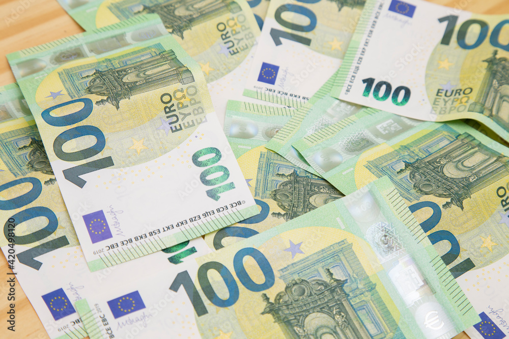 Euros scattered on wooden table with passport Euros scattered on wooden table with passport