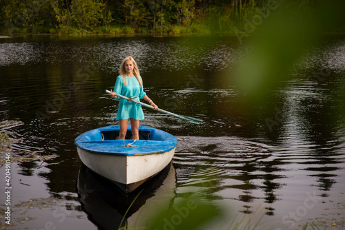 A woman riding on the back of a boat in a body of water © Ekaterina
