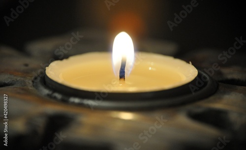 Candle Tealight burns with fire close up view macro closeup