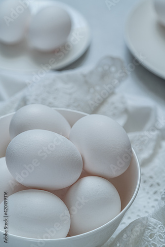 White eggs on a white plate on a white background. Easter eggs photo concept.