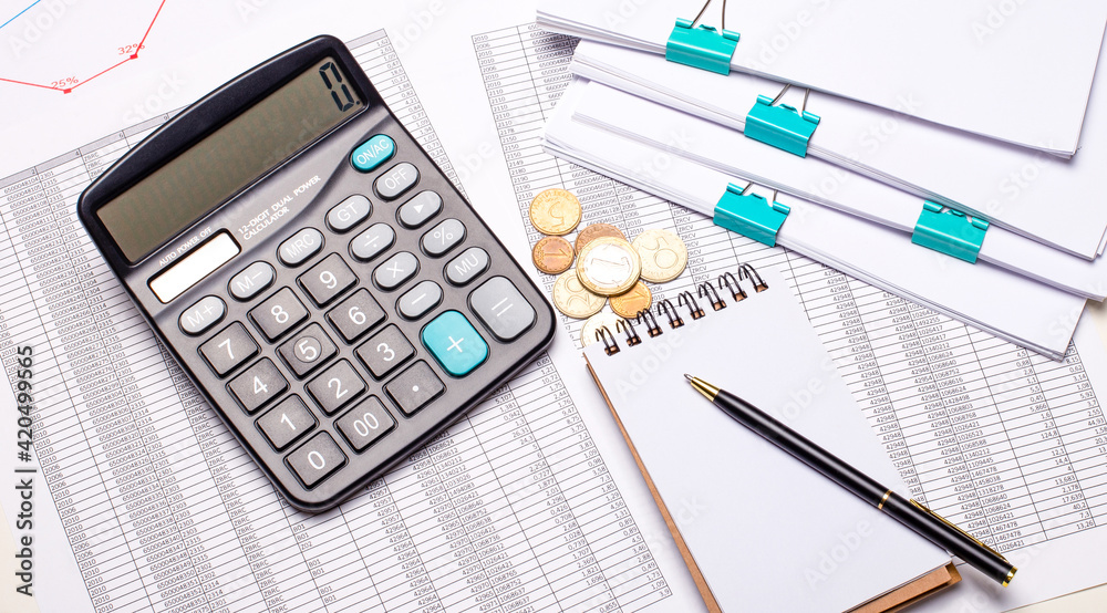 On the desktop there are reports, calculator, cash, pen and notepad. Business concept. Flat lay On the desktop there are reports, calculator, cash, pen and notepad. Business concept. Flat lay