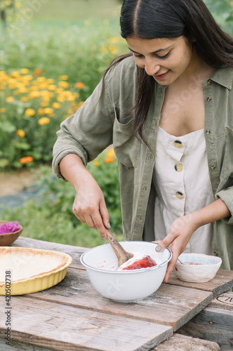 Young Woman Making Fresh Pie With Wild Berries And Flowers
