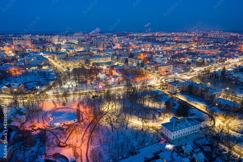 Beautiful evening top view of the city. Evening, night illumination in the city. Winter city in the snow.