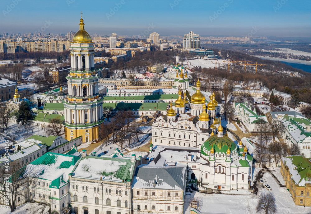 Beautiful winter top view of the Kiev-Pechersk Lavra. Many churches in the snow. Beautiful panorama of Kiev in the afternoon.