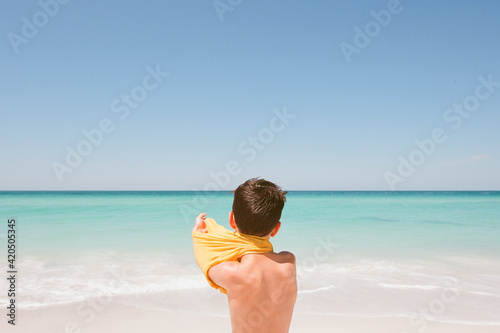 Boy puts on shirt photo