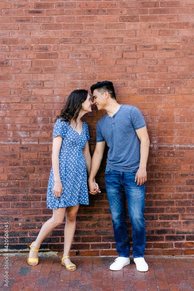 adorable couple in front of wall adorable couple in front of wall