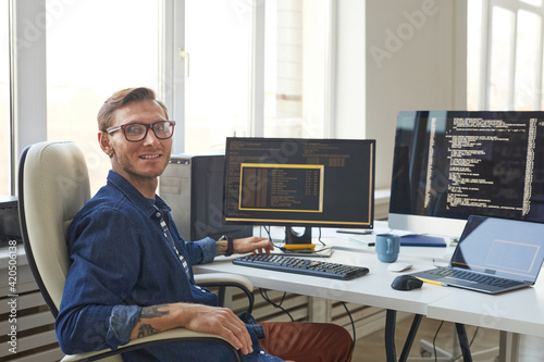 Portrait of IT Programmer Using Computers with Code on Screen photo