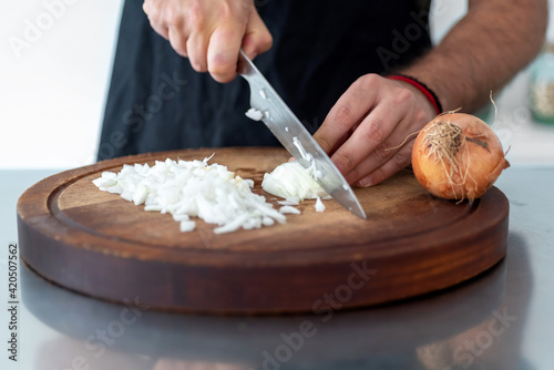 Closeup of a man cutting onion in the kitchen photo