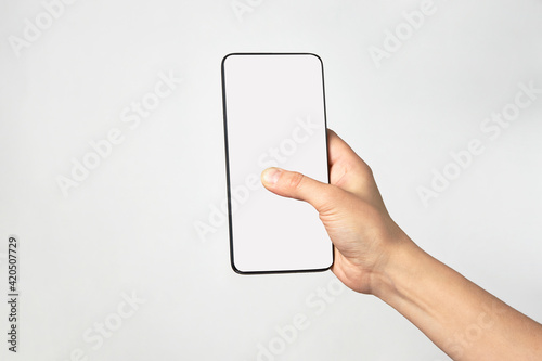 Woman hand holding phone on white background with copy space