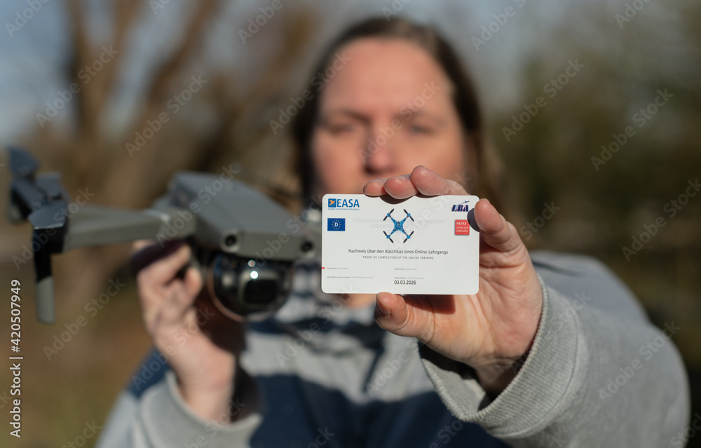 Frau hat erfolgreich den Drohnen Piloten Führerschein gemacht, dabei hält  sie eine DJI Mavic Pro 2 Drohne und die DJI Fernbedienung in der Hand  素材庫相片| Adobe Stock