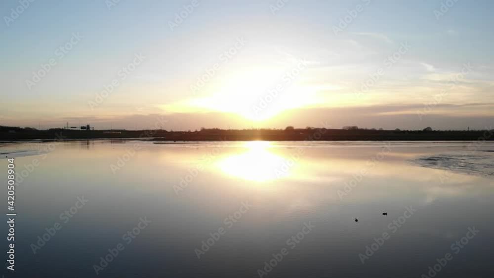 Ducks in a pond at sunset. Aerial view, flying over a pond or a lake Ducks in a pond at sunset. Aerial view, flying over a pond or a lake