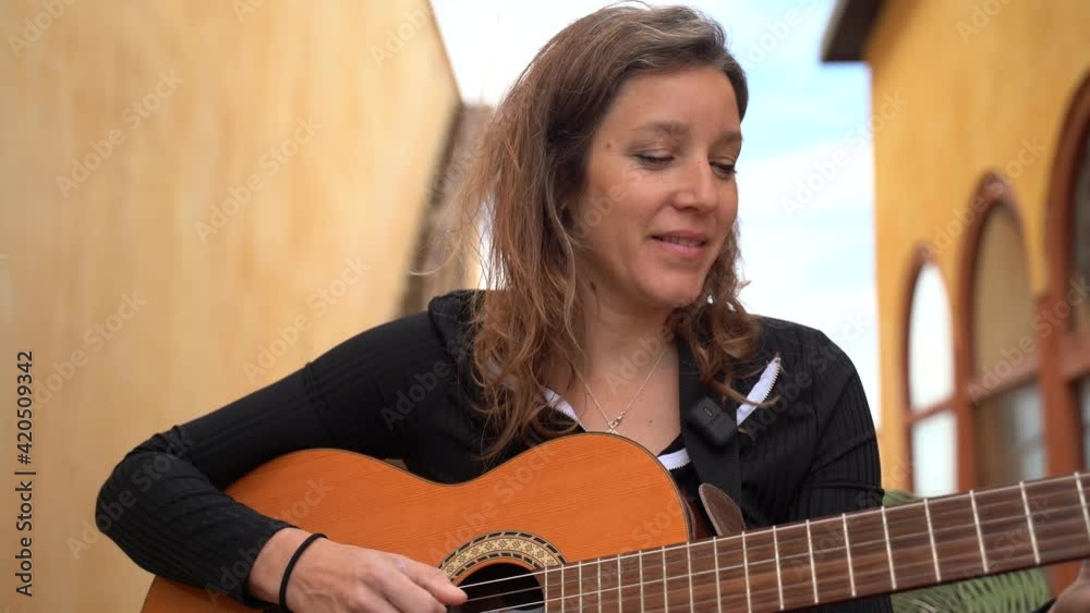 Cantante tocando la guitarra y cantanto en la terrazza