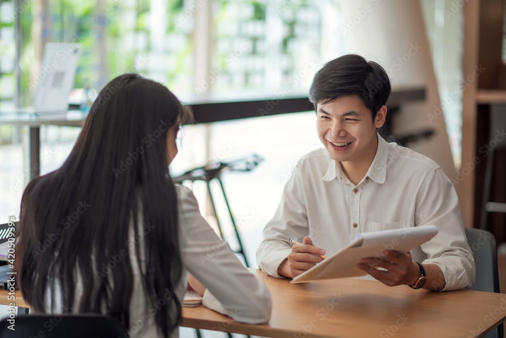 Asian businessman explain his work for coworkers at the café.