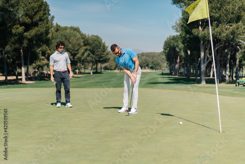 Adult men playing golf together photo