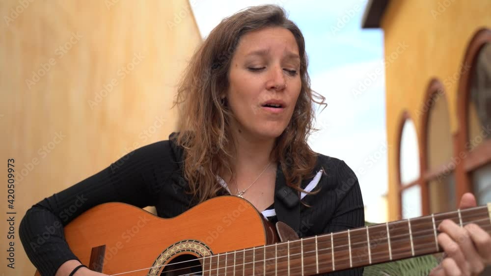 Cantante tocando la guitarra y cantanto en la terrazza