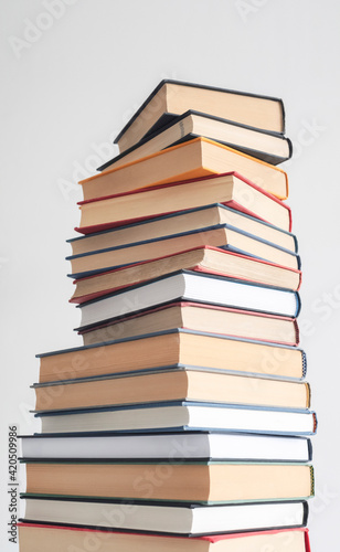 Tall stack of hard back books in various shapes and colours