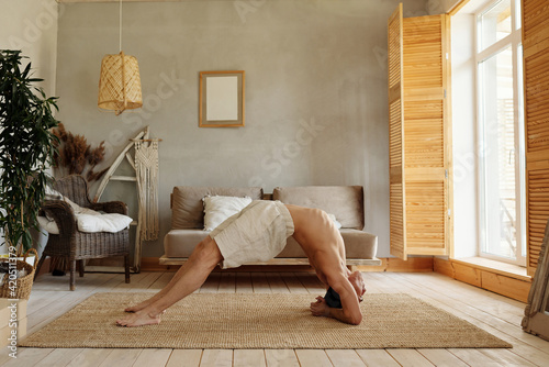 Flexible man practicing modified bridge pose photo