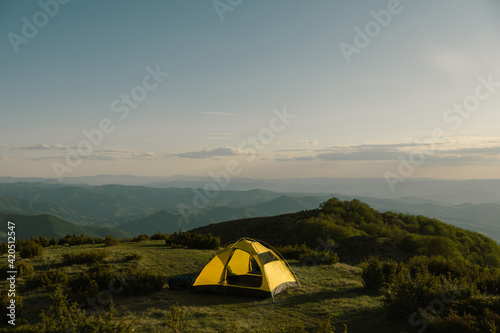 Camping tent on mountain top at sunset