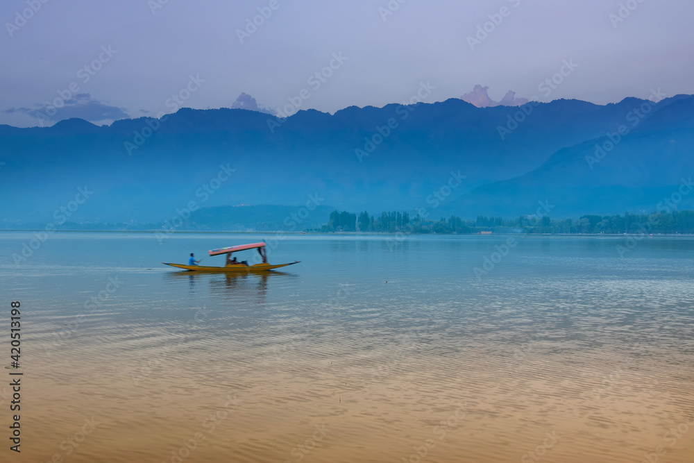 Reflection of Himalayan mountains on Dal Lake, Srinagar, Jammu and Kashmir, India. Houseboats floating on the lake in late afternoon.