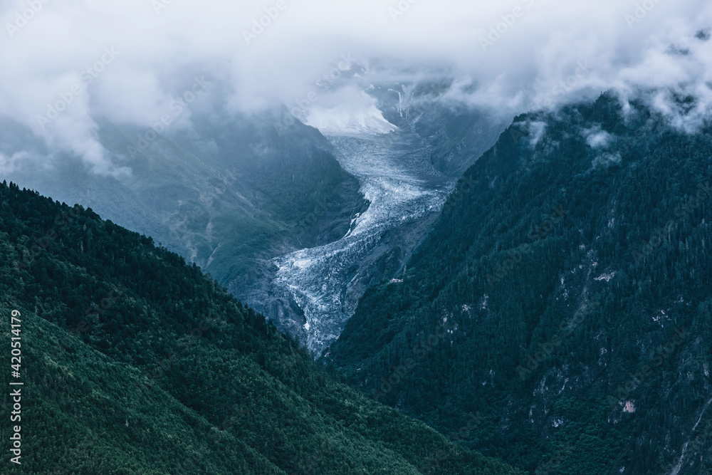 Fototapeta premium A section of glacier under the clouds between high mountains
