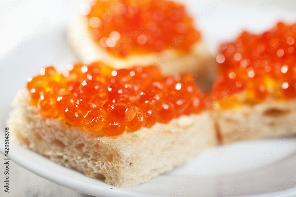 Salmon caviar on pieces of white bread macro Salmon caviar on pieces of white bread macro