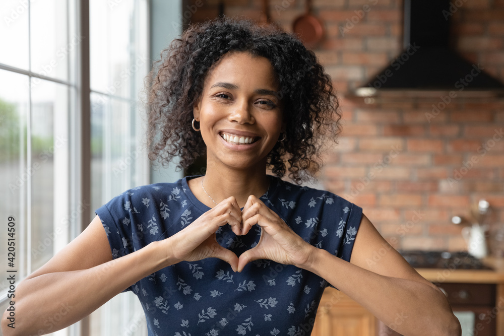 I love you. Portrait of thankful young african lady blogger appreciate for support of vlog channel hold fingers joined in like sign. Headshot of loving black female looking at camera show heart symbol I love you. Portrait of thankful young african lady blogger appreciate for support of vlog channel hold fingers joined in like sign. Headshot of loving black female looking at camera show heart symbol