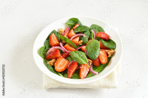 Healthy breakfast with fruit salad from strawberry, spinach and walnut